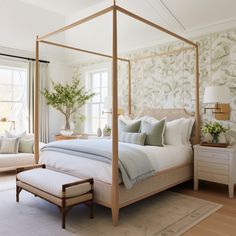 a bedroom with a four poster bed and white walls