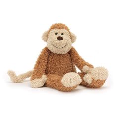 a stuffed monkey sitting on the ground with its legs spread out and eyes wide open