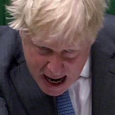 a man in a suit and tie making a face with his mouth open while looking down