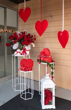 valentine's day decorations on display in front of a building with hearts hanging from the ceiling