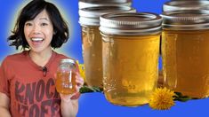 a woman holding a mason jar full of honey next to three jars filled with honey