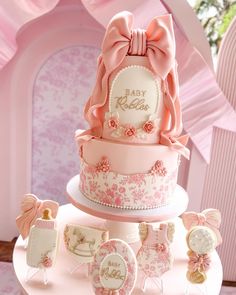 a pink and white baby shower cake on top of a table