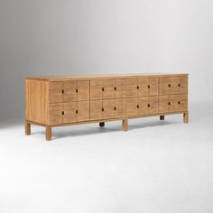 a large wooden dresser sitting on top of a white floor next to a gray wall