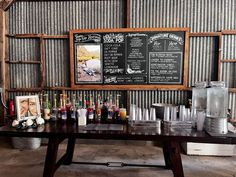 a table with drinks on it in front of a chalkboard sign that says the menu