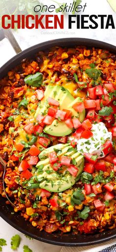 a skillet filled with chicken and rice topped with avocado