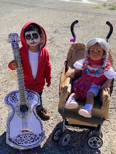 two dolls in costumes sitting next to each other with guitars on the ground behind them