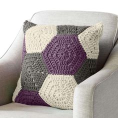 a gray chair with a purple and white pillow on it