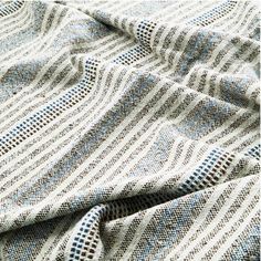 a close up view of a blanket with blue and white stripes on the fabric,