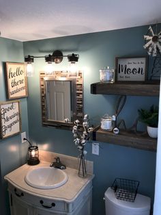 there is a bathroom with blue walls and white fixtures on the shelves above the sink