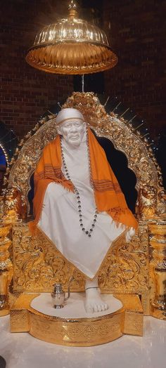 there is a statue of buddha in the middle of a table with gold decorations on it