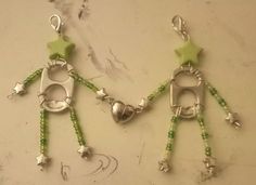 two pairs of green beaded earrings with silver stars and beads on them, hanging from hooks