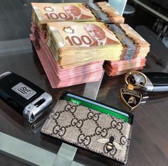 there are many different items on the table including keys, money, and wallets