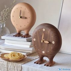 two wooden clocks sitting next to each other on a table