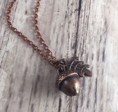 This simple Cottagecore inspired charm necklace features a tiny 15x10mm antiqued copper toned acorn pendant and a tiny 15x9mm copper toned oak leaf charm. It is all tied together with antique copper toned toned chain and an antiqued copper toned lobster clasp. The acorn  pendant is stationary in the center of the necklace, while the leaf can move playfully around the chain. The warm copper adds to this necklace's rustic, woodland charm! This is the perfect way to celebrate the upcoming autumn season. I can make this into any length you would like~ feel free to include your measurements in the drop down menu below. Feel free to convo me if you would like to customize anything else~ I would be happy to work with you!  This would look wonderful paired with matching acorn earrings, shown in th Acorn Earrings, Cottagecore Earrings, Acorn Pendant, Acorn And Oak, Oak Leaf, Leaf Charms, Autumn Season, Antique Copper, Beautiful Necklaces