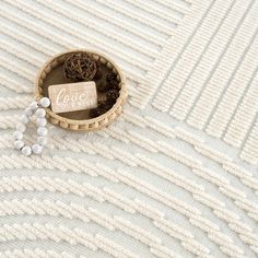 a basket filled with small white beads on top of a table next to a sign