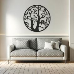 a living room with a couch and a tree wall hanging on the wall above it