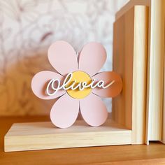 a pink and yellow flower with the word aloha cut out in it's center