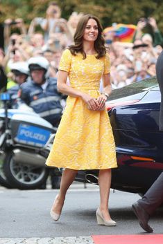 the duke and princess of cambridge are smiling as they walk past a car with people in the background