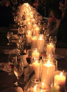 a long table with many lit candles on it