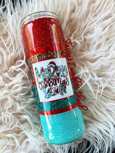 a red and blue glitter tumbler sitting on top of a white fur covered floor