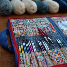 several crochet needles are laying on a quilt