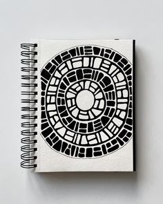 a spiral notebook with black and white designs on it