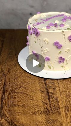 a white cake with purple flowers on it