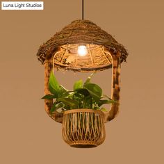 a plant in a basket hanging from a light fixture that is made out of bamboo