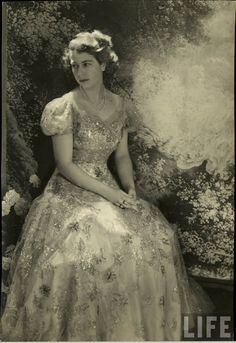 an old black and white photo of a woman in a dress