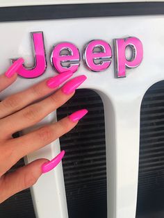 a woman's hand with pink nail polish on top of a white jeep sign