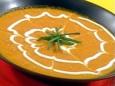 a black bowl filled with soup and garnished with green onions