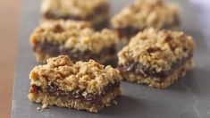 several pieces of food sitting on top of a black tray covered in crumbs