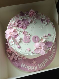 a pink and white birthday cake in a box with the number 80 written on it