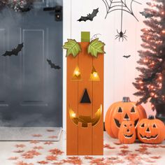 a door decorated for halloween with pumpkins and bats