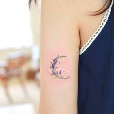 a woman's arm with a tattoo on it that has purple flowers growing out of it