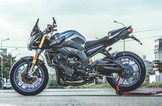 the motorcycle is parked on the side of the road in front of some power lines