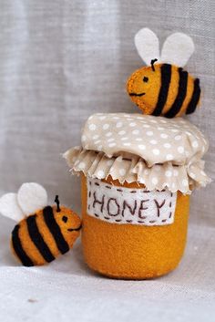 two bees sitting on top of a jar filled with honey