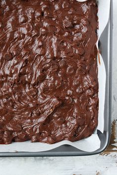 a pan filled with chocolate frosting on top of a table