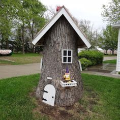 a toilet is placed in the shape of a tree stump with a house built into it