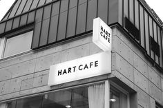 a black and white photo of the front of a building with a sign that says hart cafe