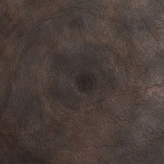 the surface of an old, brown leather texture is shown in close up and diagonal view