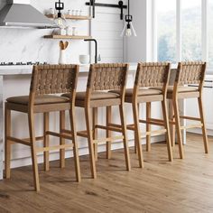 a set of four bar stools sitting on top of a hard wood floor next to a kitchen counter