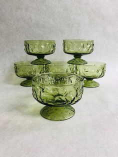 six green glass bowls sitting on top of each other