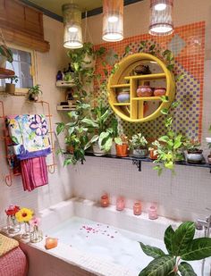 a bathtub with plants and candles in the corner next to potted plants on shelves