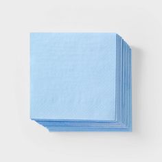 six blue napkins stacked on top of each other in front of a white background