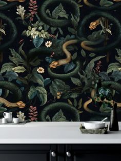 the wallpaper in this kitchen is decorated with green snakes and flowers, along with other plants