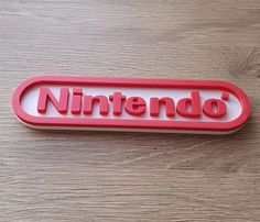 a red nintendo logo sitting on top of a wooden table