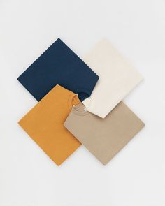 four different colors of t - shirts on a white surface with one folded and the other unzipped