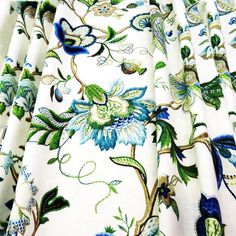 the fabric has blue and green floral designs on it's white color scheme, which matches with the rest of the material