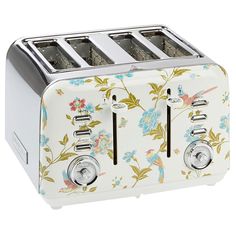 a white toaster with floral designs on the front and two slices cut in half